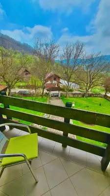 a green bench on a balcony with a view of a park at Vila Djordjevic - Priroda vas okruzuje in Brus