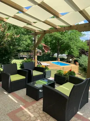 a patio with chairs and a table and a pergola at Vila Djordjevic - Priroda vas okruzuje in Brus