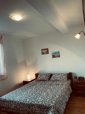 a bedroom with a bed and two pictures on the wall at Apartmani Vila Goč in Goč