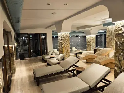 a lobby with couches and chairs and a stone wall at Milmari P79 in Kopaonik