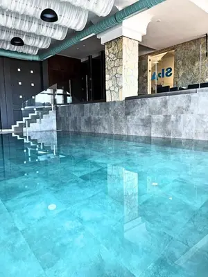 a swimming pool with blue water in a building at Milmari P79 in Kopaonik