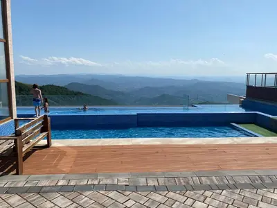 a swimming pool with a view of the mountains at Milmari P79 in Kopaonik