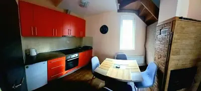 a kitchen with red cabinets and a table with chairs at Ema A2 Kraljevi Čardaci in Kopaonik