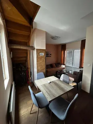 a living room with a wooden table and chairs at Ema A2 Kraljevi Čardaci in Kopaonik