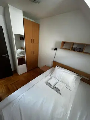 a bedroom with a white bed with two books on it at Ema A2 Kraljevi Čardaci in Kopaonik