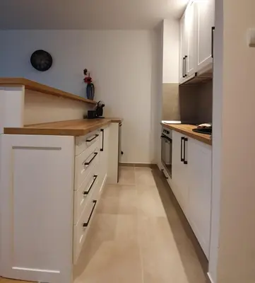 a kitchen with white cabinets and wooden counter tops at Vila Irina Kopaonik - Apartman IN in Kopaonik