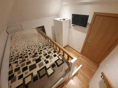 a small room with a bed and a television at Vila Irina Kopaonik - Apartman IN in Kopaonik