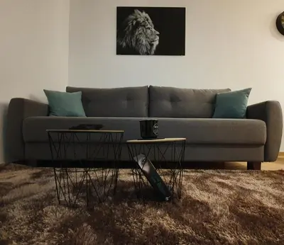 a living room with a couch and two tables at Vila Irina Kopaonik - Apartman IN in Kopaonik