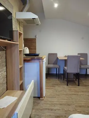 a room with chairs and a table and a kitchen at Lela in Jošanička Banja