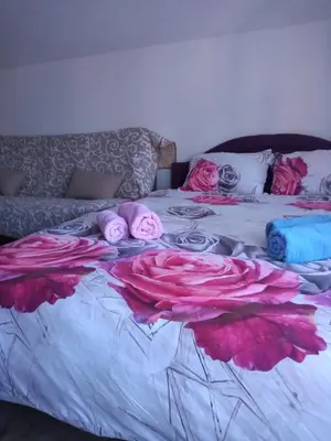 a bed with pink pillows and pink flowers on it at Lela in Jošanička Banja