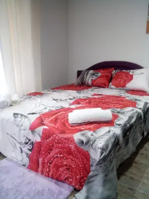 a bed with red and white blankets and pillows at Lela in Jošanička Banja