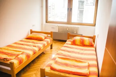 a room with two beds and a window at Aparment Theatre in Niš