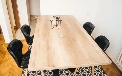 a wooden table with black chairs around it at Aparment Theatre in Niš