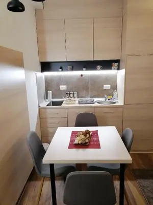 a small kitchen with a white table and chairs at President Kop S9, S3 & A103 in Kopaonik