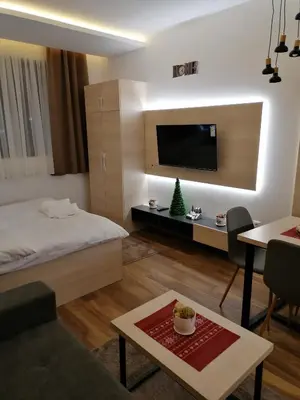 a living room with a bed and a tv on a wall at President Kop S9, S3 & A103 in Kopaonik