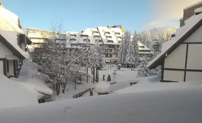 a snow covered street in a city with buildings at Mali Medved Konaci in Kopaonik