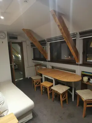a room with a table and some chairs and a couch at Mali Medved Konaci in Kopaonik