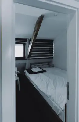 a bedroom with a white bed with a window at Mali Medved Konaci in Kopaonik