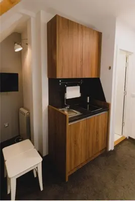 a kitchen with a sink and a table in a room at Mali Medved Konaci in Kopaonik