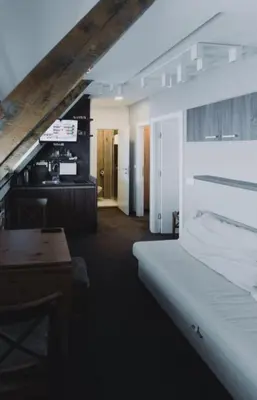 a bedroom with a bed and a desk and a kitchen at Mali Medved Konaci in Kopaonik