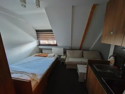a small room with a bed and a couch at Mali Medved Konaci in Kopaonik