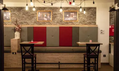 a restaurant with two bar stools in front of a bench at P20 Milmari, DeLuxe Studio, Kopaonik in Kopaonik