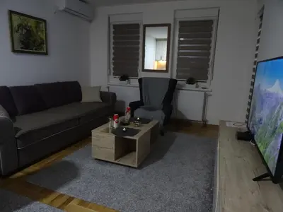 a living room with a couch and a table and a tv at Apartman N&N in Vrnjačka Banja