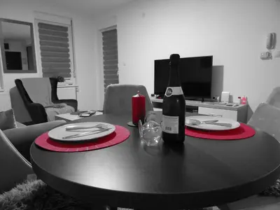 a black and white photo of a table with a bottle of wine at Apartman N&N in Vrnjačka Banja