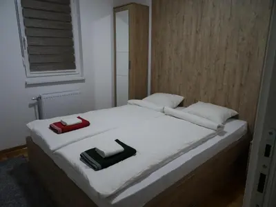 a bed with two pillows on top of it at Apartman N&N in Vrnjačka Banja