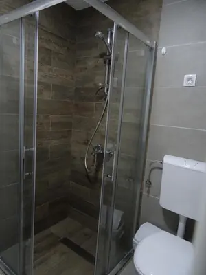 a bathroom with a glass shower with a toilet at Apartman N&N in Vrnjačka Banja