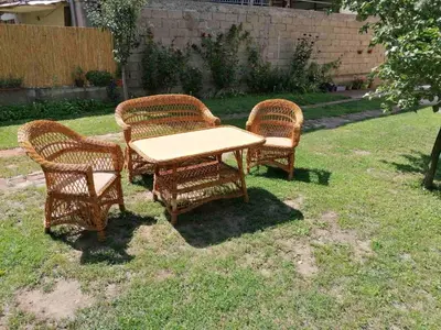 three wicker chairs and a table in a yard at Apartman Branka in Niška Banja