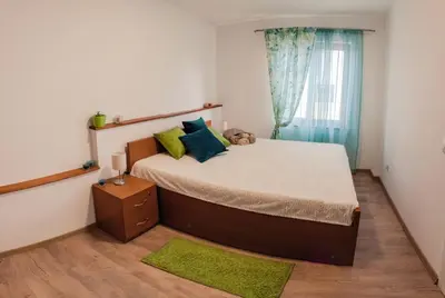 a bedroom with a large bed and a window at Apartmani Jovčić in Leskovac