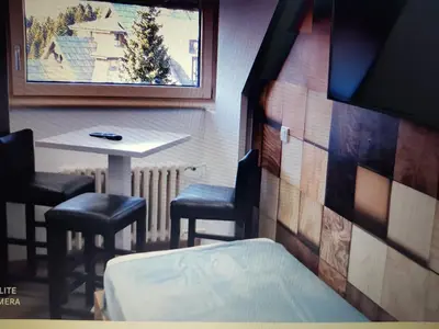 a room with a table and two chairs and a table and a bed at Apartment Kockica Konaci in Kopaonik