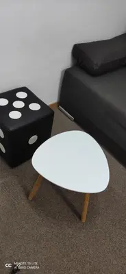 a white table next to a bed and a black dice at Apartment Kockica Konaci in Kopaonik