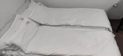 a bed with white sheets and pillows on it at Apartment Kockica Konaci in Kopaonik