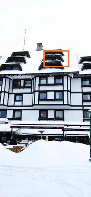 a building with snow in front of it at Apartment Kockica Konaci in Kopaonik