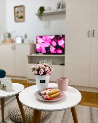 a table with a plate of food and a cup of coffee at Apartment Atria in Vrnjačka Banja