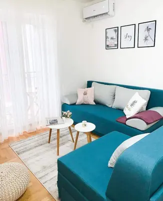 a living room with a blue couch and a table at Apartment Atria in Vrnjačka Banja