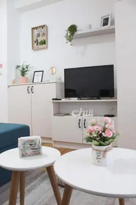 a living room with a tv and a table with flowers at Apartment Atria in Vrnjačka Banja