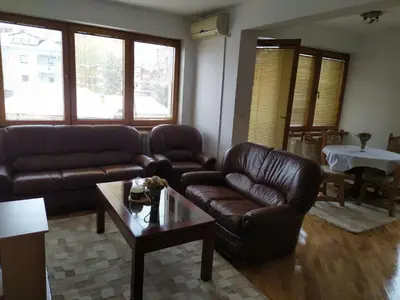a living room with leather couches and a coffee table at Apartman Miloš in Vrnjačka Banja