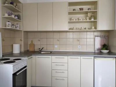 a kitchen with white cabinets and a white stove top oven at Apartman Miloš in Vrnjačka Banja