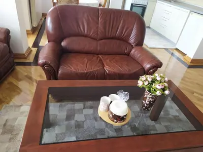 a living room with a brown leather couch and a coffee table at Apartman Miloš in Vrnjačka Banja