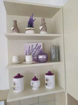 a shelf with purple and white cups and vases at Apartman Miloš in Vrnjačka Banja