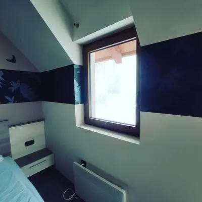 a bedroom with a blue and white striped wall at Apartman D16 Milmari Kopaonik in Kopaonik