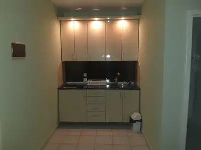 a small kitchen with white cabinets and a sink at Apartmani Nikola in Vrnjačka Banja