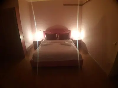 a bedroom with a bed with two lights on it at Lux Apartmani Nikola in Vrnjačka Banja