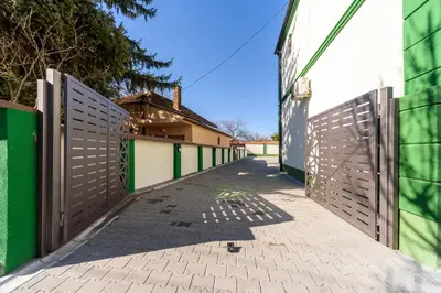 a gate to a building with a walkway at Garni Hotel Mala Moskva in Bela Palanka