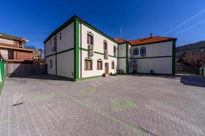 a building with green and white on a street at Garni Hotel Mala Moskva in Bela Palanka