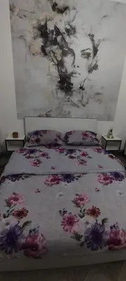 a bedroom with a bed with a painting on the wall at Apartman Jasna, in Pirot