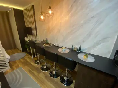 a room with a bar with chairs and a wall at Grand Elegant & Spa Kop in Kopaonik